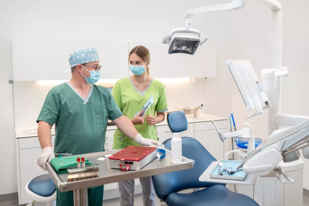 Zahnärztliches Team in OP-Kleidung und Maske bereitet Instrumente in moderner Zahnarztpraxis in Radstadt vor